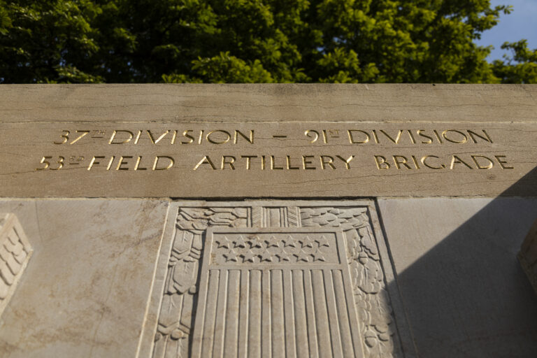 The monument of golden-yellow limestone stands at the end of a small park