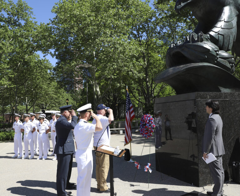 Ceremony participants salute after laying a wreath during the Battle of the Atlantic 75th Anniversary Ceremony at the East Coast Memorial.