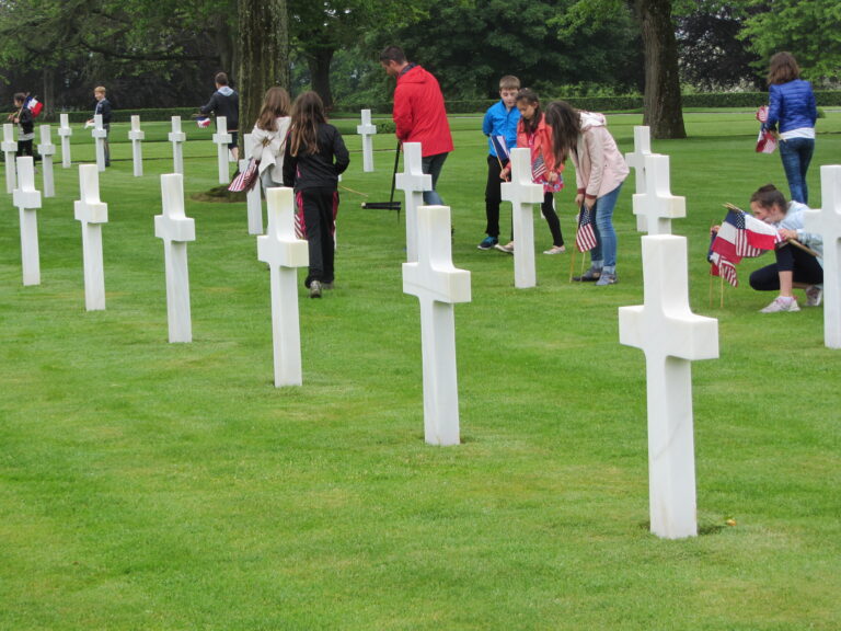 Local students assist in the placement of American and French flags at every headstone for the 2016 Memorial Day Ceremony at Brittany American Cemetery.