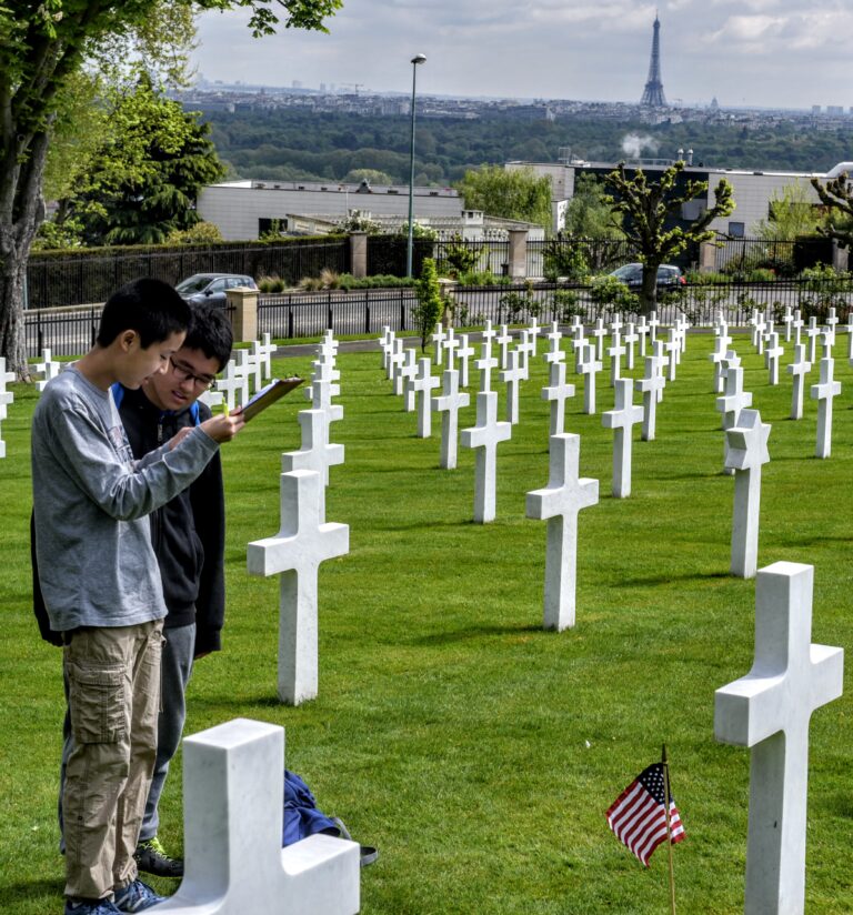 Students from the American School of Paris discuss a new project while visiting Suresnes American Cemetery. Photo credit: Thomas Neville/American School of Paris.