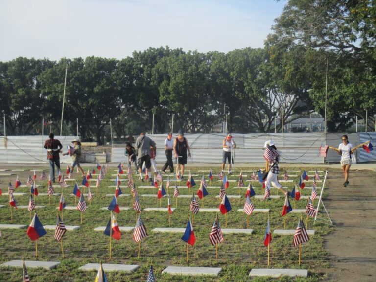 Volunteers place an American and Filipino flag at every grave site in preparation for the 2017 Memorial Day Ceremony at Clark Veterans Cemetery.