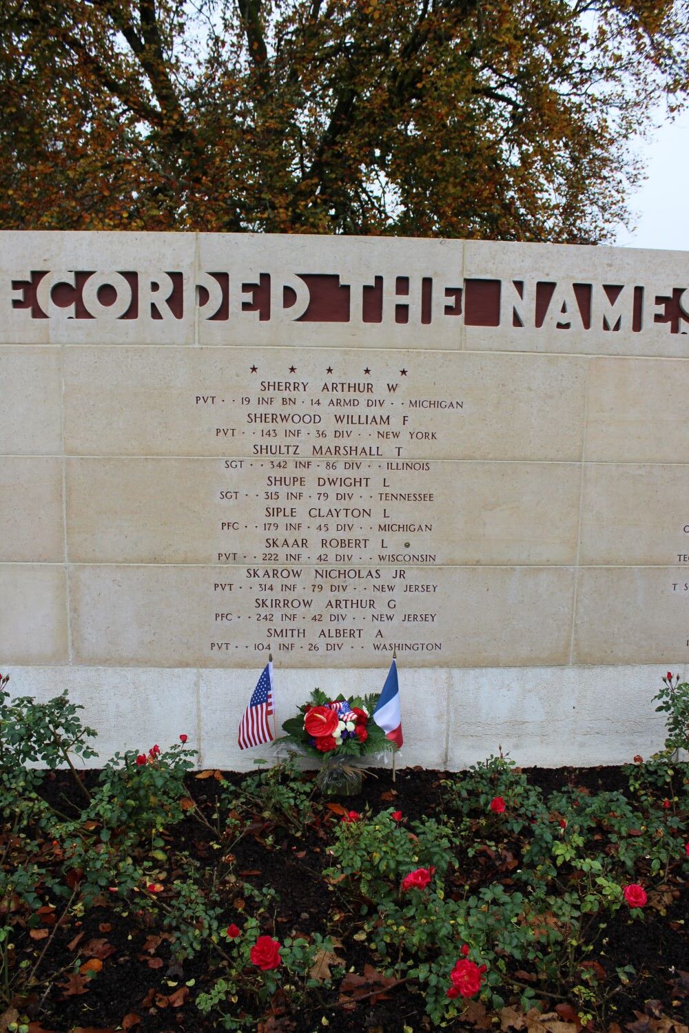 A bronze rosette is placed next to the name of Robert Skaar on the Walls of the Missing