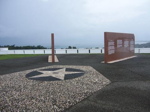 Two of the marble walls of the memorial are seen at an angle. Water is visible in the distance.