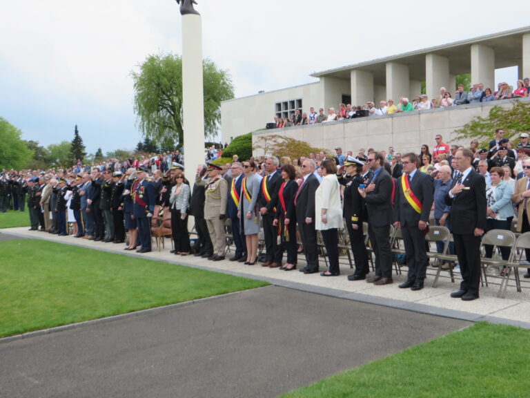 Members of the crowd stand during the 2016 Memorial Day Ceremony at Henri-Chapelle American Cemetery.