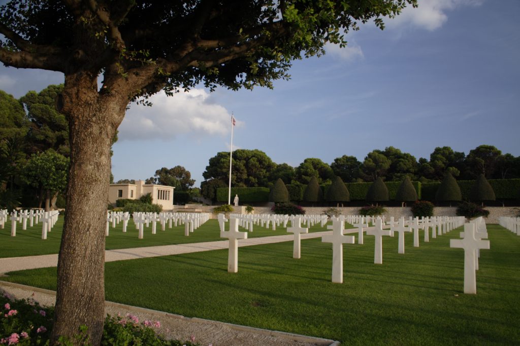 Picture of North Africa American Cemetery with the headstones and the flagpole. Credit: American Battle Monuments Commission/ Robert Uth.