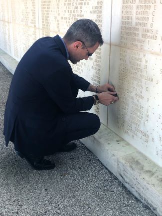 U.S. Ambassador to the Republic of Tunisia Joey R. Hood places a rosette on the wall of the missing