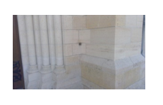 The chapel at Aisne-Marne American Cemetery in France underwent repairs in the wake of World War II to address damage inflicted during nearby fighting. This artillery hole near the entrance of the building was left, however, as an intentional reminder of what had happened during the war. Credit: ABMC 